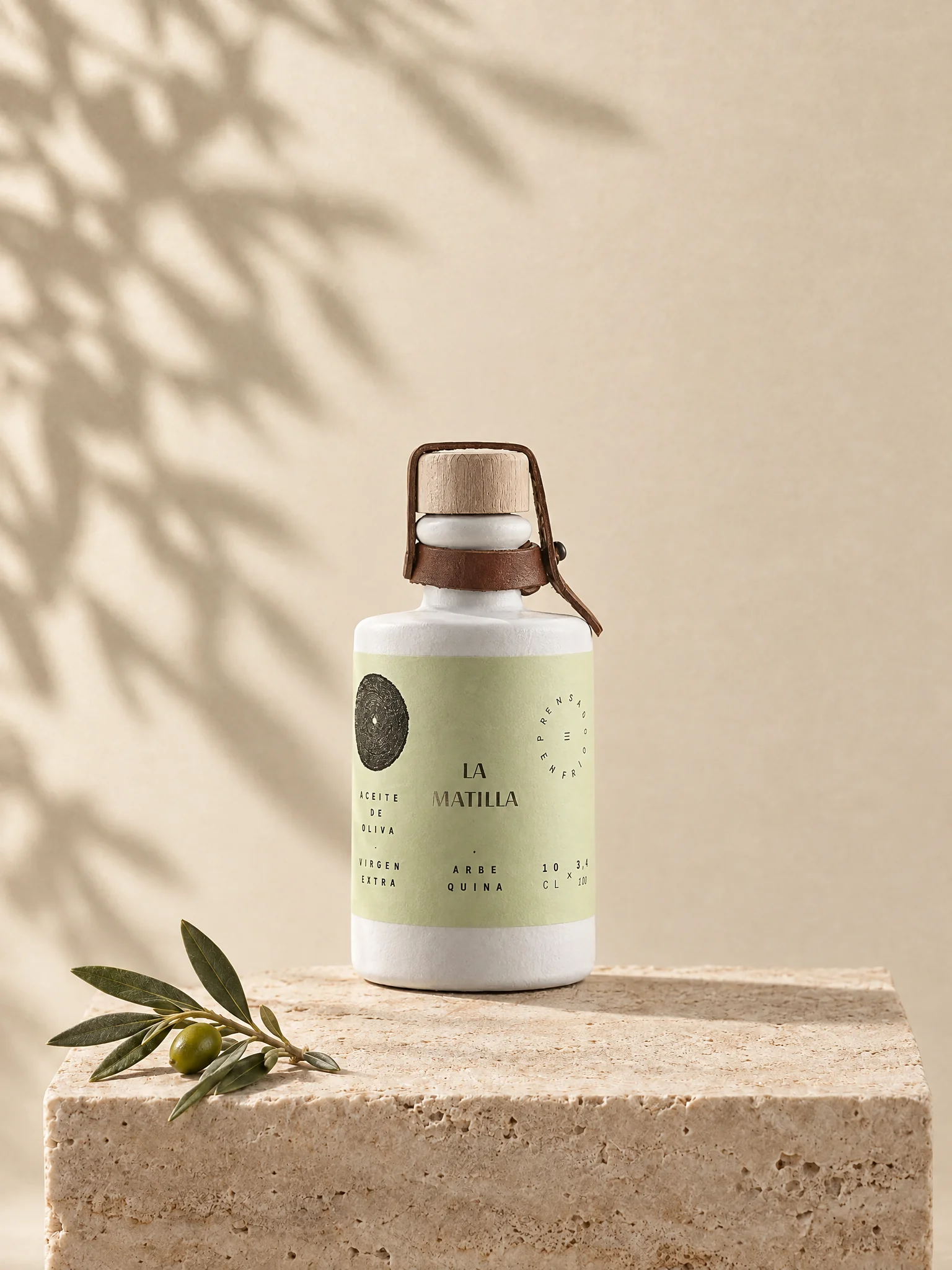 Botella de cerámica de 100 ml de AOVE Arbequina La Matilla sobre una peana de travertino