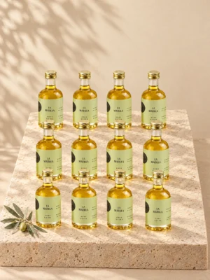 Doce botellitas de 50 ml de AOVE Arbequina La Matilla de pie sobre una peana de travertino